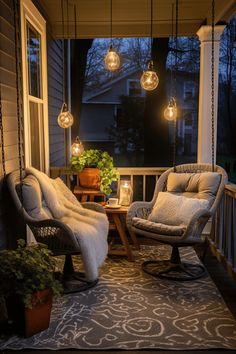 two chairs on a porch with lights hanging from the ceiling and plants in pots next to them