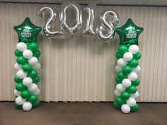 balloon columns are decorated with green and white balloons for the new year's eve celebration