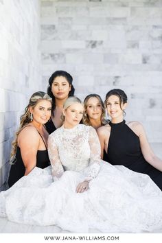 a group of women in black dresses posing for a photo