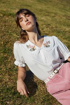 Embroidered blouse featuring darling Robin birds and cherry blossoms, cottagecore style with a large collar and lace trim. Crafted from a soft textured cotton fabric- large rounded collar with lace edge trim- subtle v neckline- button through front- puff short sleeves with a dainty cuff- sweet flower and robin motifs embroidered on collar- crafted from a textured cotton fabric- available in cream Product Code: PGFY020 Feminine Spring Tops With Lace Collar, Cotton Blouse With Floral Embroidery And Doll Collar, Spring Feminine Blouse With Lace Trim, Collared Cotton Blouse With Lace Trim, Feminine Lace Trim Blouse For Spring, Spring Blouse With Cute Collar, Spring Embroidered Tops With Doll Collar, Feminine Spring Blouse With Lace Collar, Embroidered Doll Collar Top For Spring