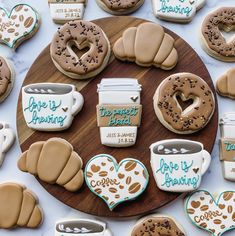 decorated cookies and coffee mugs on a wooden platter with the words love is caring