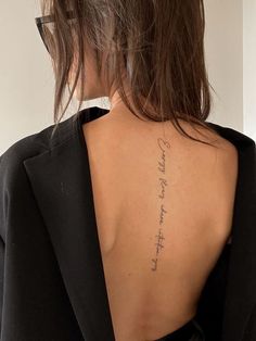 the back of a woman's neck with writing on her left shoulder and right arm