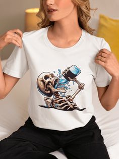 "Make a bold statement with our Skeleton Drinking Graphic Tee! This unisex T-shirt features an eye-catching design of a skull pouring a magical liquid, creating a unique illusion as it flows through the ribcage. Perfect for those who love edgy streetwear, this tee is made from high-quality, comfortable fabric that's suited for any casual occasion. The cool skull illustration stands out, ensuring you grab attention wherever you go. Whether you're looking for a conversation starter or a distinctive piece to add to your collection, this T-shirt won't disappoint. Great as a gift for the fashion-forward individual in your life. Order now and add a splash of daring style to your wardrobe! We utilize the authentic Bella Canvas 3001 brand, renowned for its UNISEX design, making it one of the most Astronaut Riding A Rocket, Skeleton Drinking, Edgy Streetwear, Retro Dog, Skull Illustration, Novelty Shirts, Motorcycle Tshirts, Unisex Design, Pet Clothes