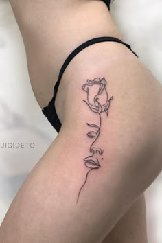 a woman's thigh with a rose tattoo on it