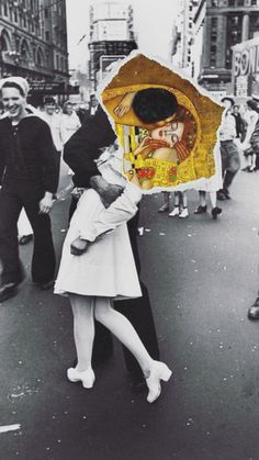 a man and woman kissing in the middle of a crowded street with people walking around