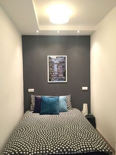 a bed sitting in a bedroom next to a wall with pictures on the wall above it