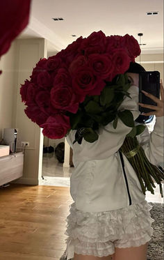 a woman taking a selfie with flowers on her head in front of a mirror