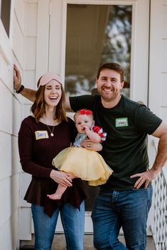 a man standing next to a woman holding a baby