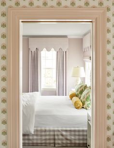 a bedroom with pink walls and white bedding