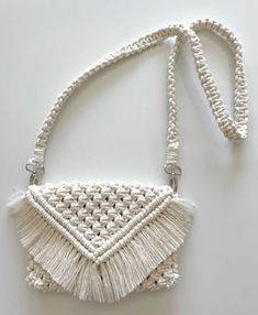 a white purse with tassels hanging from it