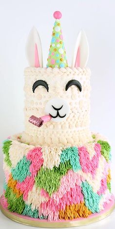 a birthday cake with a llama wearing a party hat