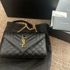 Saint Laurent Shoulder Bag In Quilted Powder-Grain Lambskin Leather. Convertible Shoulder Strap That Can Be Worn As A Crossbody Bag Or Doubled For A Shoulder Bag, 55cm Drop Sliding Leather/Chain Shoulder Strap, 14.4" Drop. Envelope Top With Metal Ysl Monogram; Snap Closure. Exterior, On Flat Open Pocket At Back. Golden Hardware Interior, One Main Compartment And One Flat Pocket. Textile Lining. Bag Weighs Approx. 1.8 Lb./ 0.8 Kg. Approx. 6.3"H X 9"W X 2.4"D. Comes With Dust Bag & Box. Made In It Ysl Bag Outfit, Designer Belt Bag, Yves Saint Laurent Bags, Leather Satchel Bag, Monogrammed Leather, Saint Laurent Bag, Leather Chain, Leather Satchel, Cute Bags