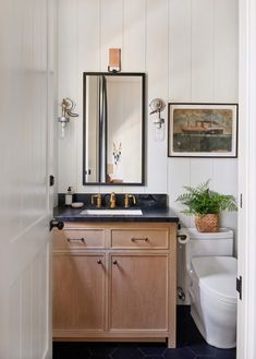 a bathroom with a sink, mirror and toilet