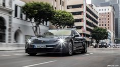 a black sports car driving down the street