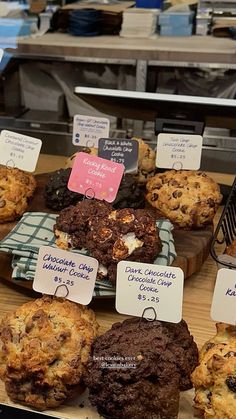 a display case filled with lots of cookies and muffins on top of wooden boards