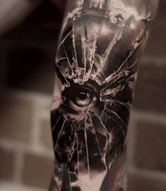 a man's arm with a black and white tattoo on it, depicting an eye in