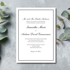 an elegant wedding card with greenery on the side and white paper in the middle