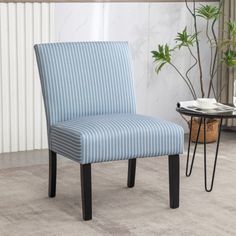 a blue striped chair sitting on top of a carpeted floor next to a table