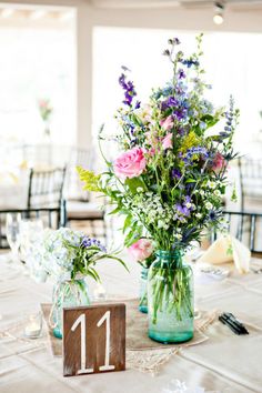 two vases filled with flowers sitting on top of a table