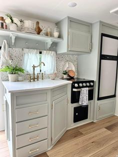 a kitchen with gray cabinets and white counter tops