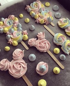 some pink and yellow cupcakes on top of a cookie sheet covered in icing