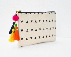 Black and off white triangle print pouch - multipurpose bag or purse can be used for cosmetics, toiletries, school supplies, jewellery..........and many more.It is very handy and lightIt is made of black and off white triangle print cotton canvas pouch accented with bright multicoloured hand made tassel/charm.The inside is lined with matching off white cotton fabricThe bag has matching brass zip closure with brass puller Size : height - 5 inches / 13 cms          width -  9 inches / 23 cms Black And White Geometric Pattern, Fabric Paint Diy, Utility Pouch, Fabric Wallet, Triangle Print, Multipurpose Bag, Planner Charms, Embroidery Bags, Toiletry Storage