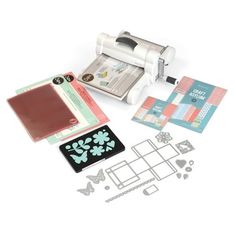 an assortment of crafting supplies including a cricut machine, paper and stickers