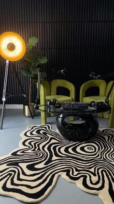 a living room with chairs and a rug on the floor in front of a lamp