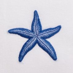 a blue star is embroidered onto a white piece of cloth with stitching on it