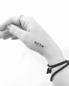 a woman's arm with the word ate tattooed on it, in black and white