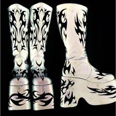 two white cowboy boots with black and white designs on the soles, side by side