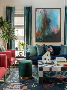 a living room filled with lots of furniture and colorful pillows on top of it's couches