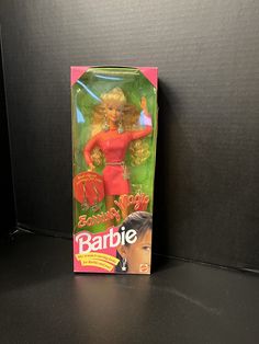 the barbie doll is in its box on the black surface with it's packaging