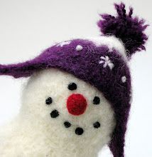 a close up of a snowman wearing a purple hat