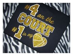 a black and gold shirt with the number four on it that says 4 at the court