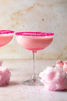 two pink cocktails with sprinkles and sugar on the rim, sitting next to each other