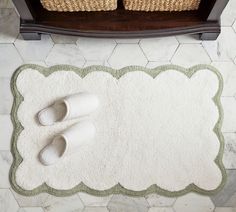 two pairs of slippers sitting on top of a white rug next to a basket