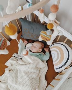 a baby is laying in a crib surrounded by stuffed animals and blankets on the floor