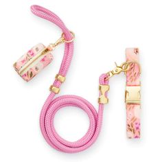 a pink leash with flowers on it and a gold hook attached to the leash is shown