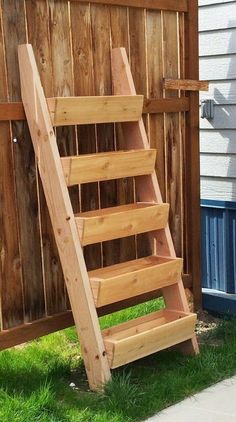 a wooden ladder sitting next to a fence