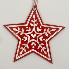 a red and white star ornament hanging from a string