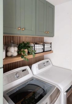 a washer and dryer in a small room with green cabinets on the wall