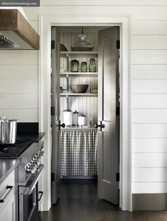 an open door leading to a kitchen with stainless steel appliances