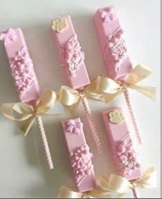 pink and gold candy sticks with bows on them