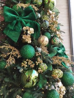 a christmas tree with green ornaments and bows