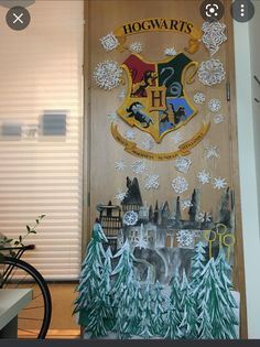 a hogwarts door decorated with snow and trees