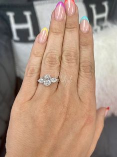 a woman's hand with two different colored nails and a ring on her finger