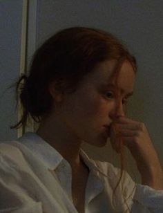 a woman in white shirt brushing her teeth