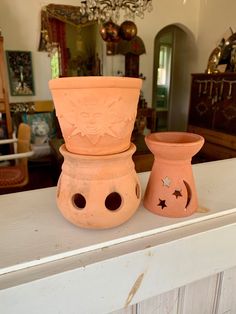 two clay pots sitting on top of a mantle