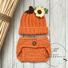 an orange crocheted hat and diaper cover with a sunflower on top